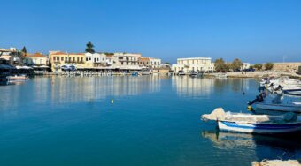A view of Rethymno Harbour, surrounded by blue skies and water.