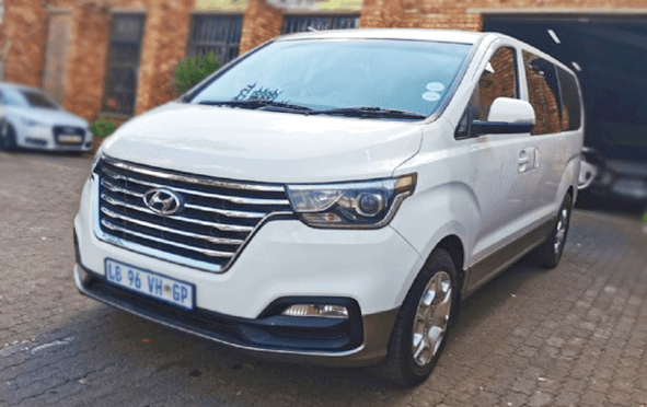 Front view of a white Johannesburg Airport taxi (Minivan)