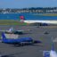 A number of planes on the tarmac outside Boston International Airport, with water separating the airport from another body of land.