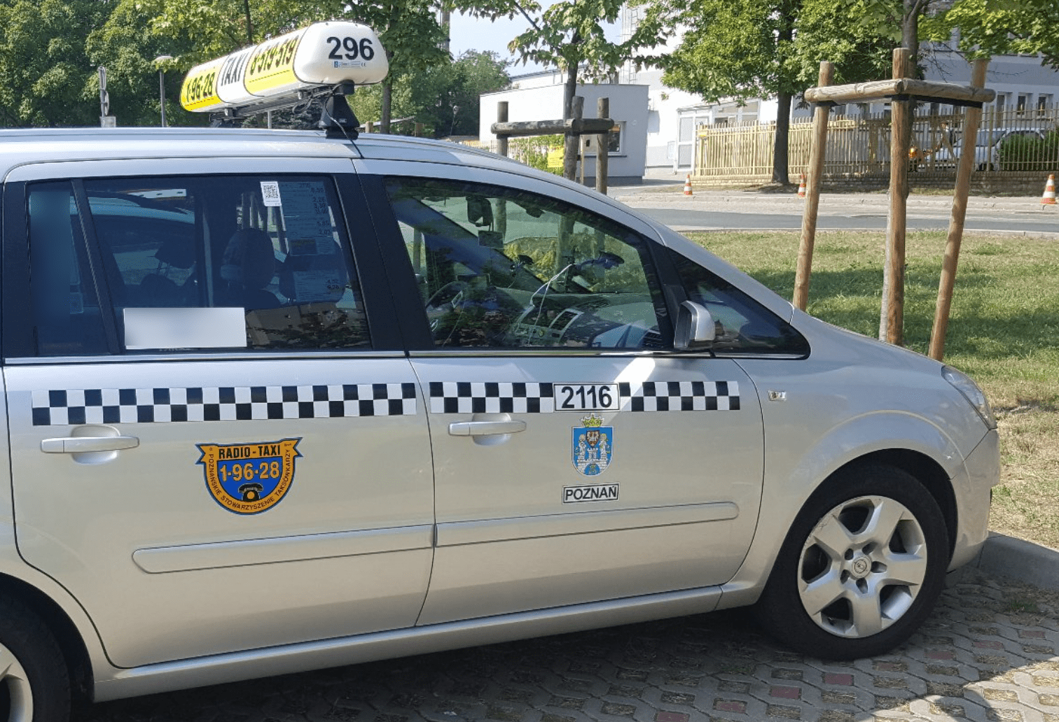 Poznan taxi Silver taxi with blue-checkered band and company logos.