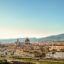 View of central Florence with mountains in the distance and blue skies above.