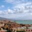View of the city of Naples, with mountains in the background and the sea up ahead.
