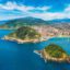 Aerial view of the San Sebastian coastline with an inlet and an island with turquoise waters and yellow sandy beaches.