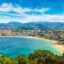 Panoramic view of a beach in San Sebastian with the city in the background.