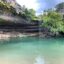 A pool of water at the base of a rocky cliff in Dripping Springs, TX.