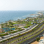 Coastal roadways, greenery, buildings, and trees line an ocean view.