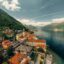 A town as the base of a large hill, bordering a large lake.