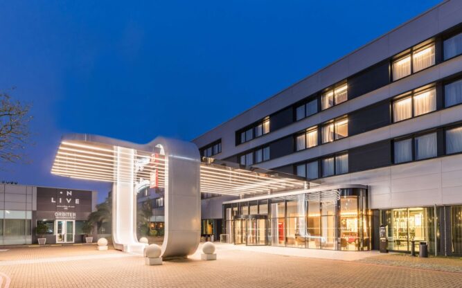 Exterior of Raddisson Red Hotel at Heathrow Airport, pictured at night with lights glowing.
