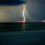 Lightning striking the ocean at Clear Water Beach in a dark sky