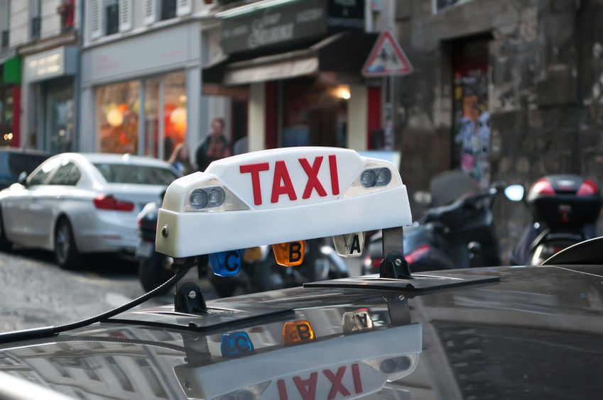 Figari Taxi White sign with 'Taxi' in red atop a Figari taxi cab.