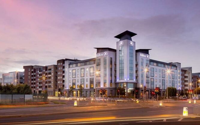 An exterior view of Hilton Dublin Airport at dusk.