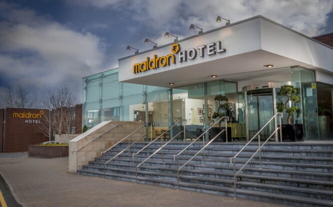 Stairs leading to the entrance of the Maldron Hotel at Dublin Airport with the hotel signage across the front of the building written in yellow and white signage