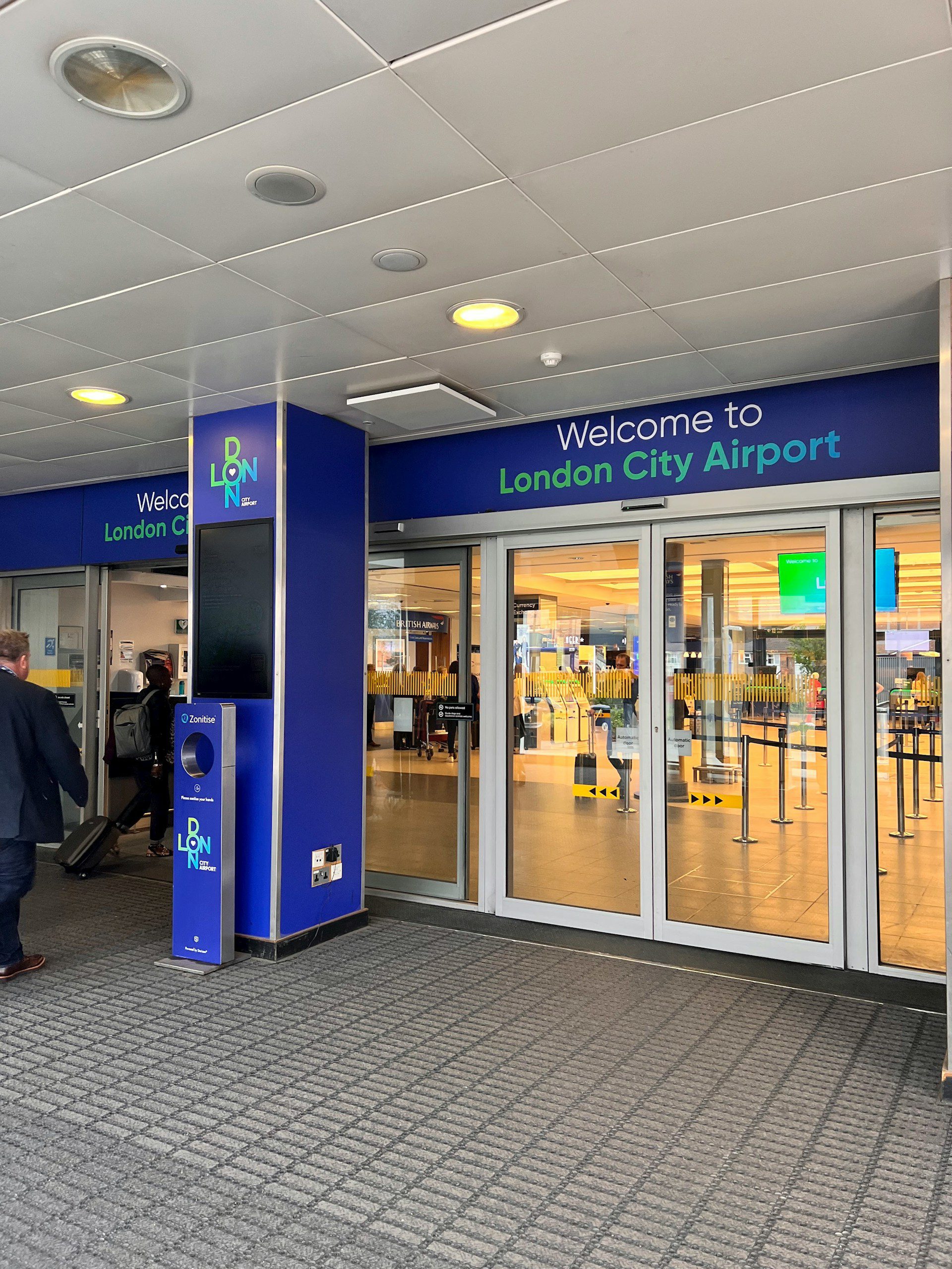 Entrance to London City Airport Terminal, with a blue rim around the doors saying Welcome.