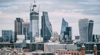 View of the city of London, showing skyscrapers with grey skies above.