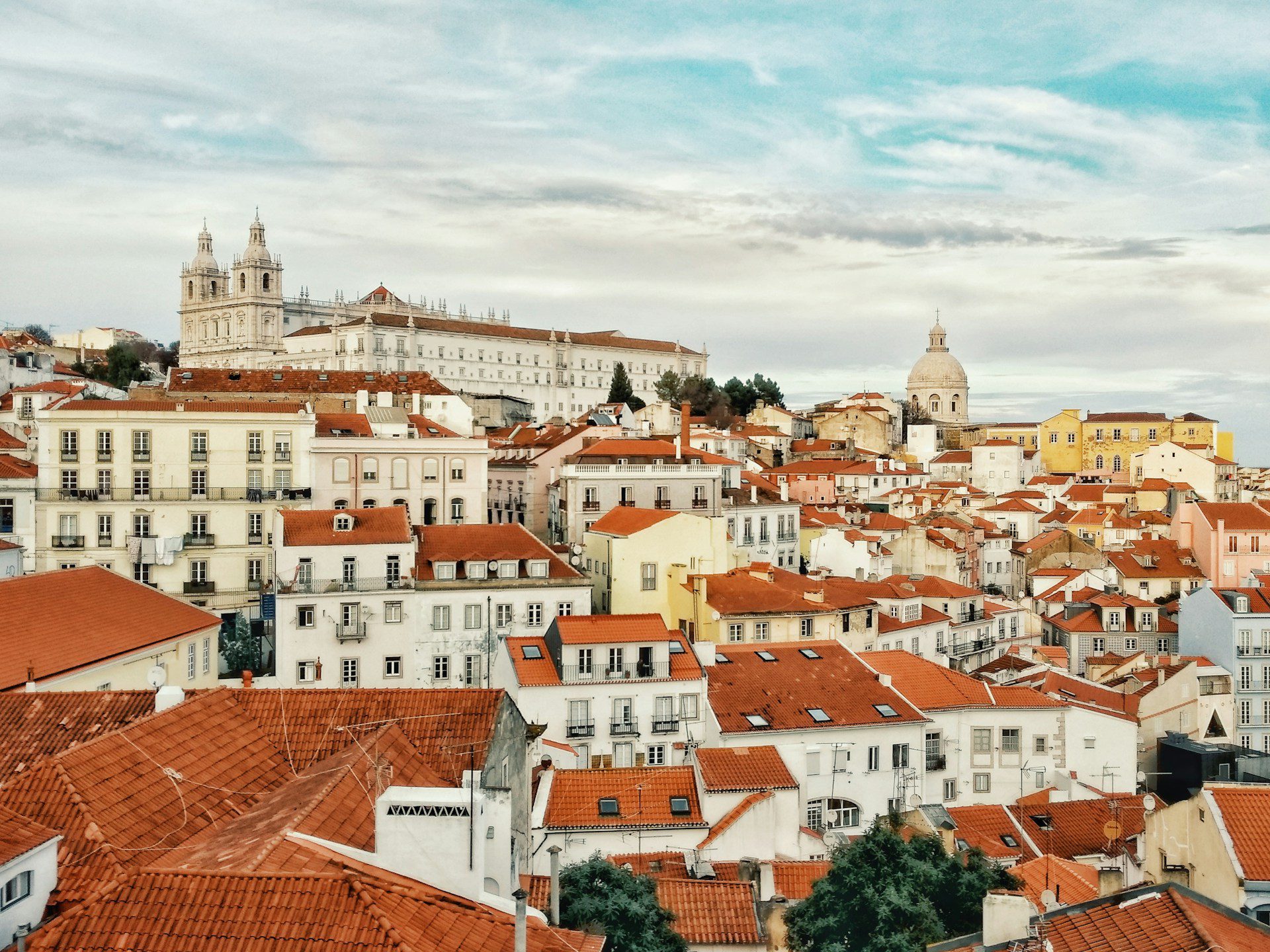Rooftop view of Lisbon city centre, with sand and terracotta coloured rooftops.