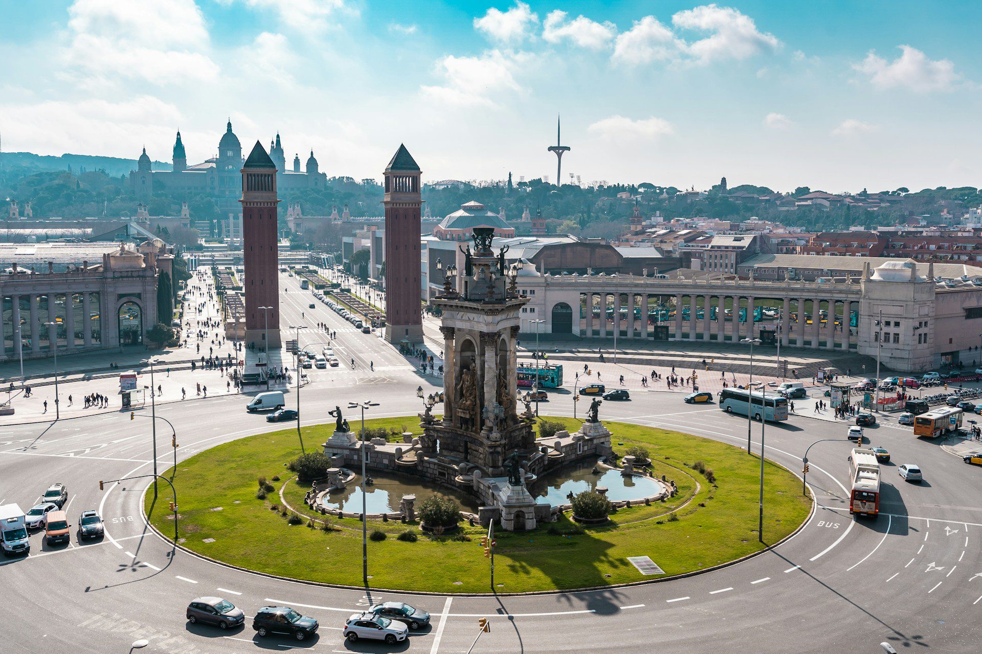 Image of Plaza de España in central Barcelona, with a grassy roundabout in the centre and two towers either side of the main exit.