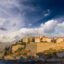 Picturesque view of the edge of Porto Vecchio over deep blue waters and a cloudy sky.