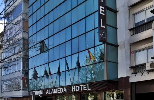 Exterior of Turim Alameda Hotel in Lisbon - front of a large glass building.