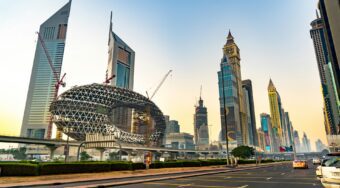 View of Dubai’s Sheikh Zayed Road at sunset, featuring the iconic Museum of the Future under construction, surrounded by modern skyscrapers and cranes. The bustling cityscape highlights a typical area serviced by Uber Dubai, offering travelers convenient access to major landmarks and business districts.