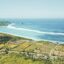 Aerial view of Lombok coastline with greenery and blue ocean.