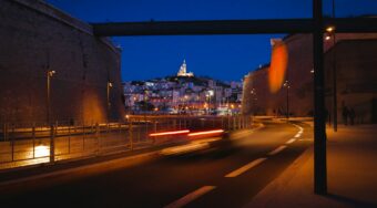 An empty street at night in Marseille, with buildings in the distance.