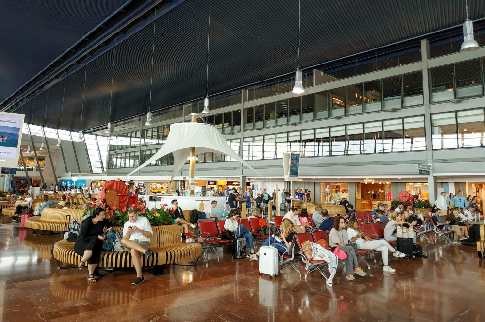A picture of passengers sitting inside Nice Airport Terminal.