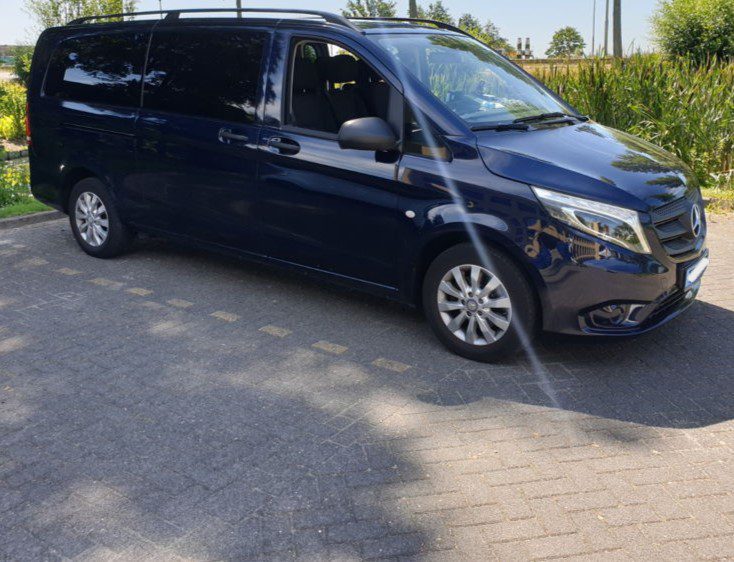 Taxi Amsterdam Airport Minivan - Welcome Pickups A black Amsterdam Airport taxi minivan parked in an outdoor parking space.
