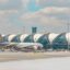 Two planes sat in front of the aircraft boarding gates.