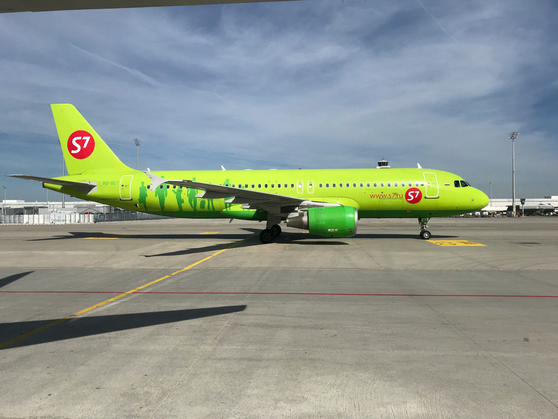 Bright green S7 Airlines plane on the tarmac at Palma de Mallorca Airport under a clear sky, ready for takeoff—typical scene from Palma Airport departures.