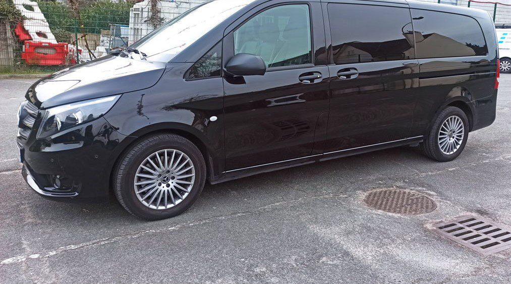 orly-airport-minibus Side view of a black Paris Orly Airport taxi parked outdoors.