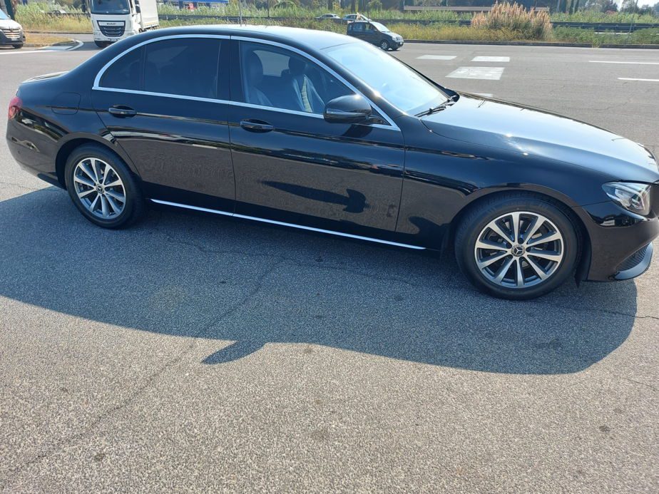 A black Ciampino Airport taxi sedan parked in an outdoor car park.