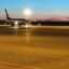 Plane taxis at dusk at Bari Airport.