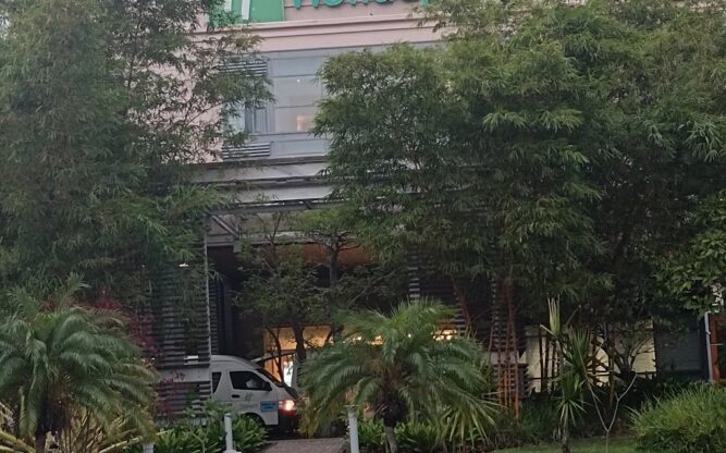The entrance to the Holiday Inn Hotel at Mauritius Airport covered over with trees and greenery.