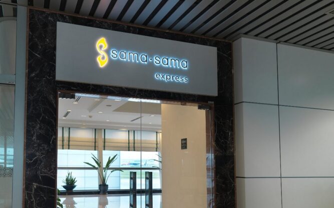 A glass door with a sign above it leading to the Sama-sama Express Hotel at Kuala Lumpur Airport