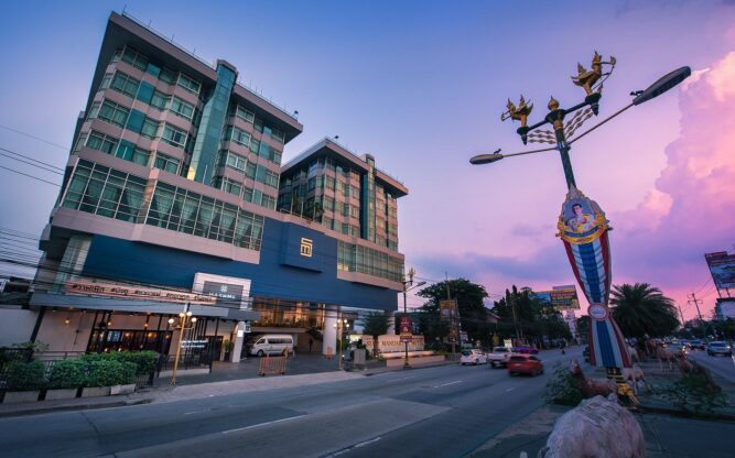 A view of the Siam Mandarina Hotel at Bangkok Airport against a purple and blue sky at dusk.