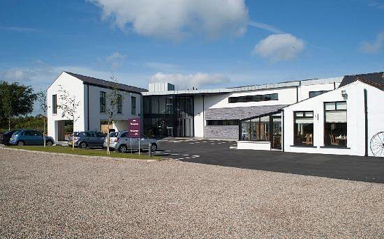 A set of white cottages serving as the Ballyrobin Country Lodge at Belfast International Airport