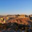 View of the Acropolis on the hill, with blue skies above.