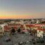 View of Faro town, showing terracotta roofs in the foreground and the sea in the background.
