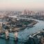 Aerial view of the city of London, with the River Thames and Tower Bridge in the center.