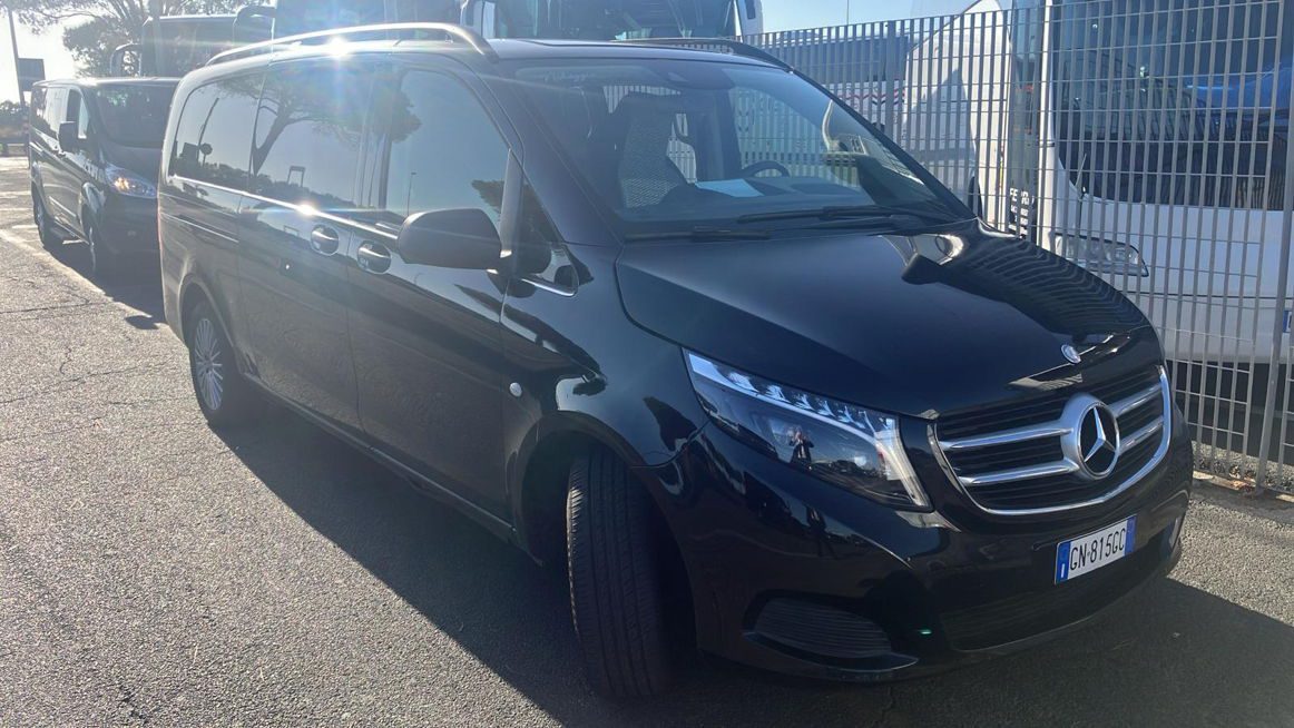 Side view of a black Civitavecchia taxi parked outside.
