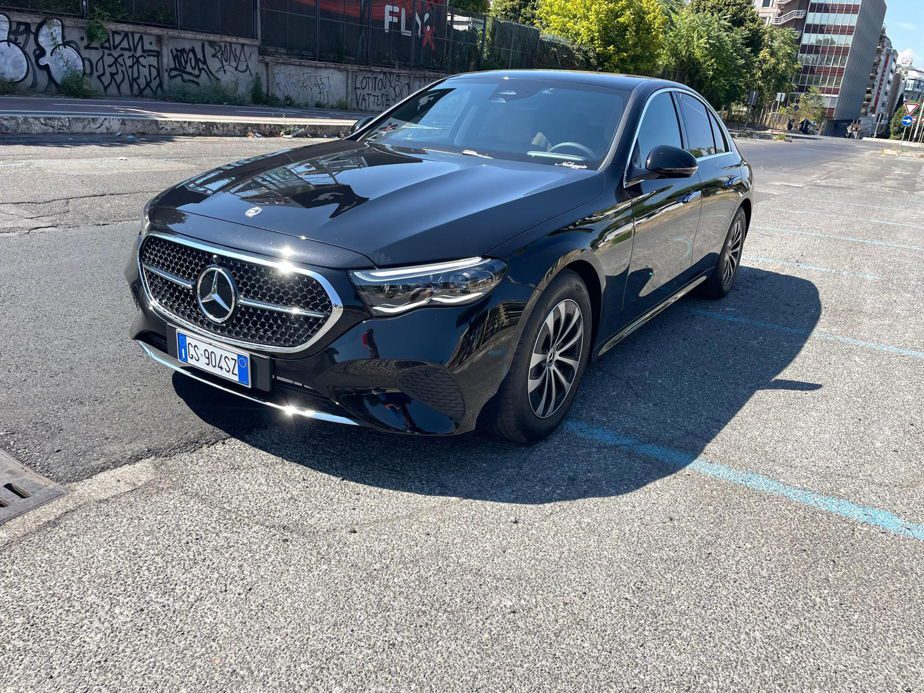 Front view of a black Civitavecchia Port taxi parked outside.