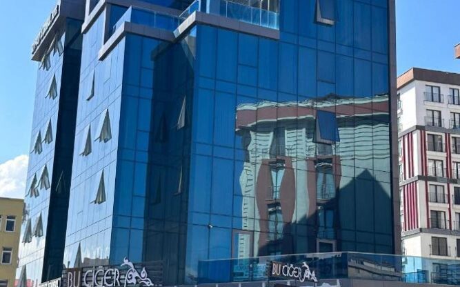 The glass Skyport Istanbul Hotel against a blue sky