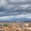 A view of a Catania city with lots of terracotta rooftops and a cloudy moody sky.