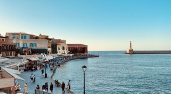 Chania Town on the waterfront, with buildings to the left and a body of water to the right.