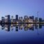 A blue night sky and the city skyline of Oslo reflected on the water.