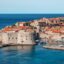 View of the walls of Dubrovnik surrounded bu blue sea.
