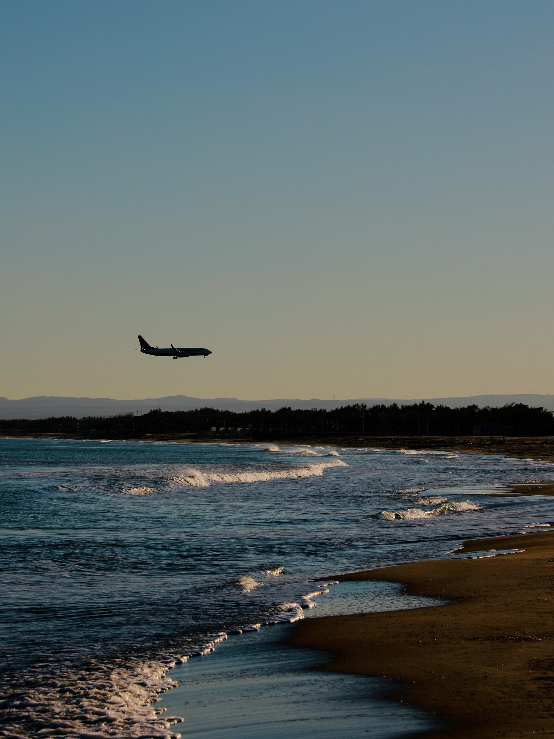 A plane departing over the sea near Catania Airport.