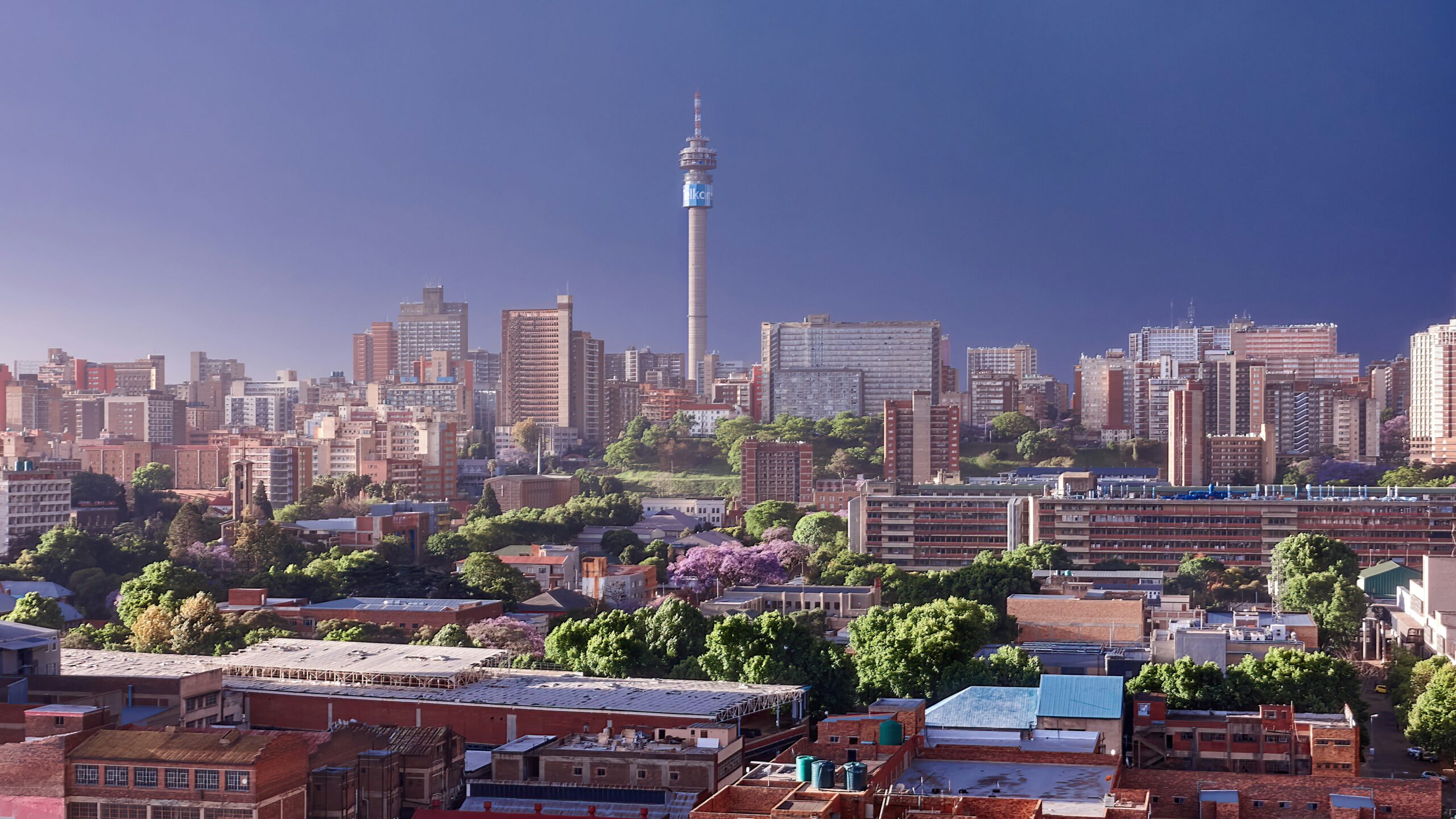 A view of Johannesburg City on a sunny day with a single tower dominating the skyline.