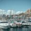 boats line the harbor in front of rocky hills