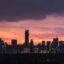 manila skyline silhouette under a dark pink orange and purple sunset sky